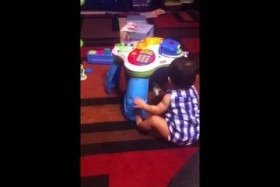 Zoe tipping her toy and clapping